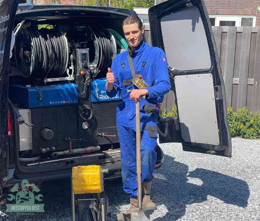 Een tevreden monteur met opgestoken duim naast de bestelbus, slim en snel ingrijpen bespaart geld bij een verstopping in Best