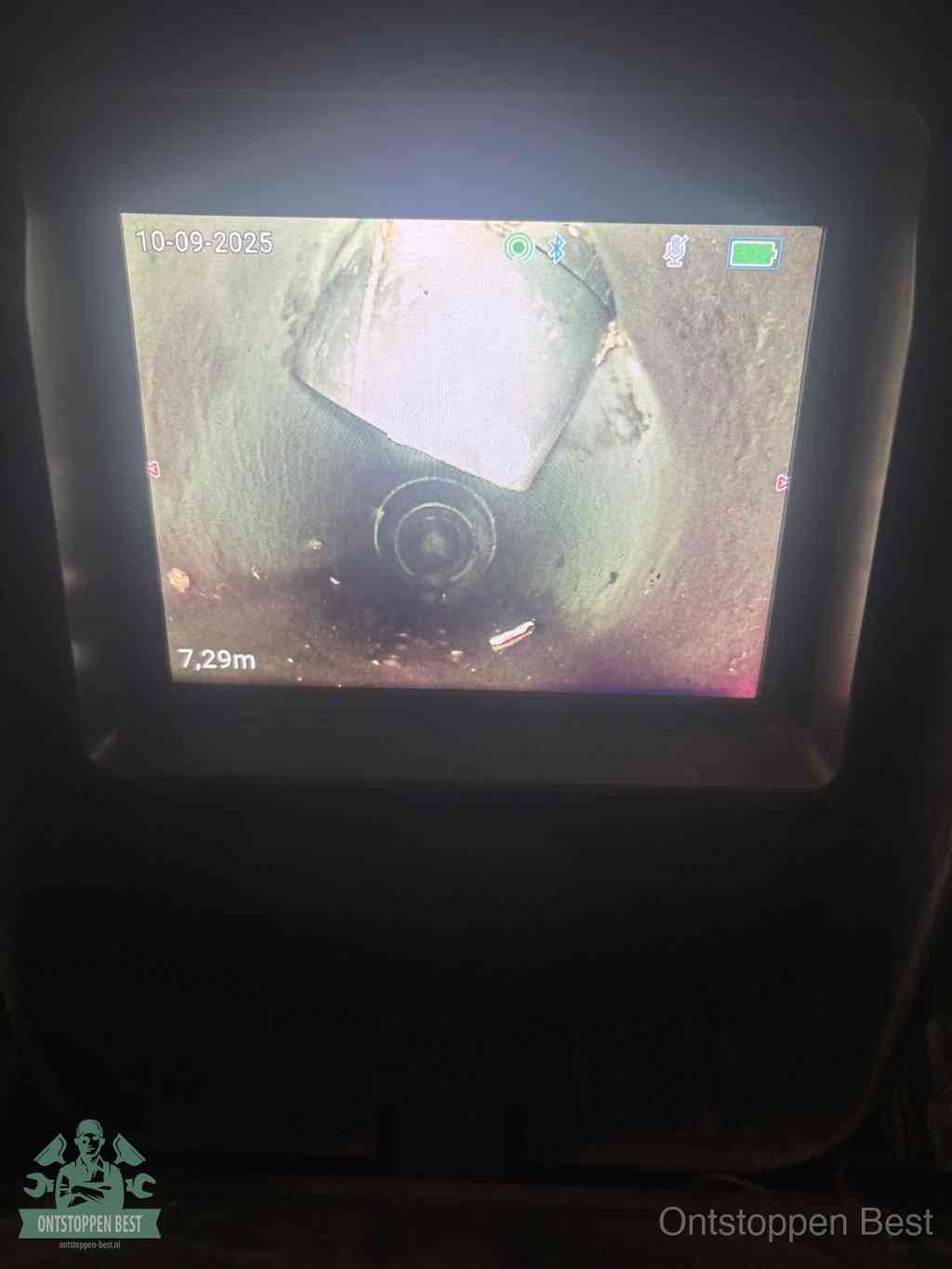 Het scherm van een rioolinspectiecamera toont de binnenkant van de leiding, eerst vaststellen waar de verstopping zit in Best