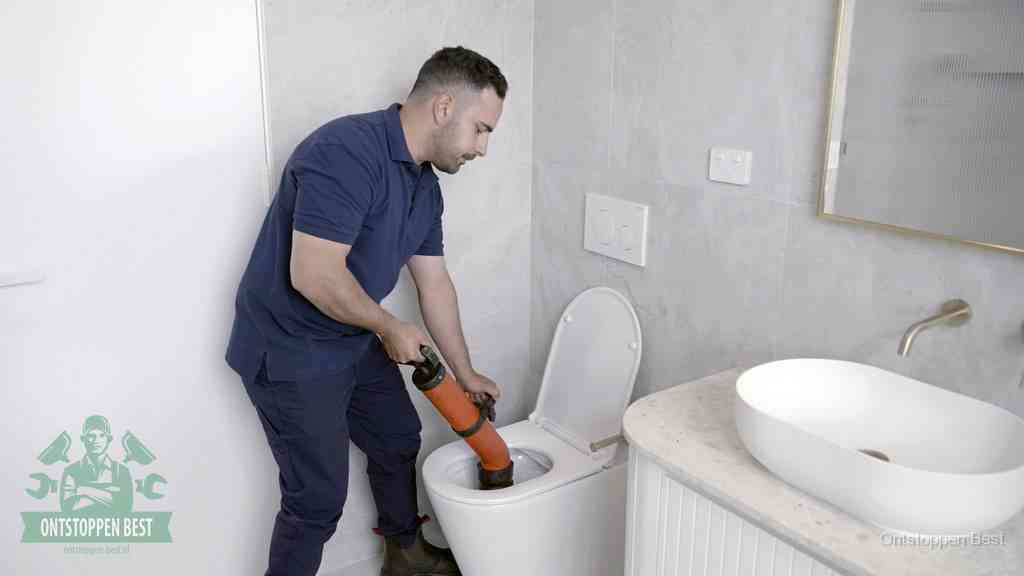Een wc wordt met een handmatige ontstopper losgepompt, een verstopt toilet zelf ontstoppen met huismiddelen in Best